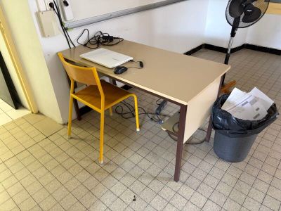 un bureau avec un ventilateur et une chaise dans une pièce