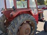a red tractor that is parked in a parking lot