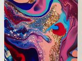 a close up of a colorful painting with gold glitter on it