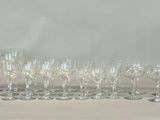 many wine glasses and a decanter sitting on a table