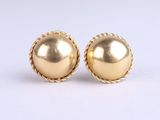 une paire de boucles d'oreilles en or sur fond blanc