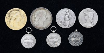 six médailles d'argent et d'or de différentes tailles sur fond noir