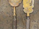 deux cuillères en argent et une cuillère en argent sur une table
