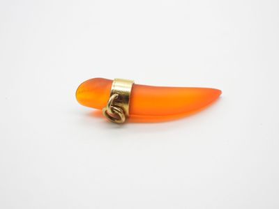un gros plan d'un petit objet orange posé sur une surface blanche