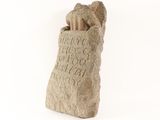 a stone statue of a dog holding a book