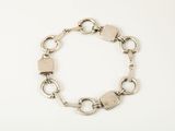 a close up of a silver bracelet on a white surface