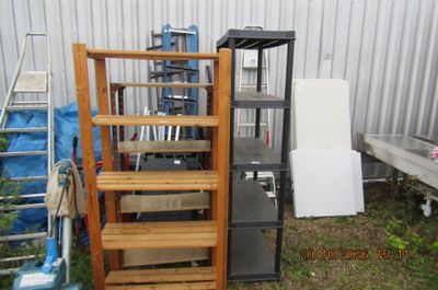 une échelle appuyée contre un mur, à côté d'une pile de cartons
