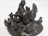 a statue of a woman sitting on a bench surrounded by chickens