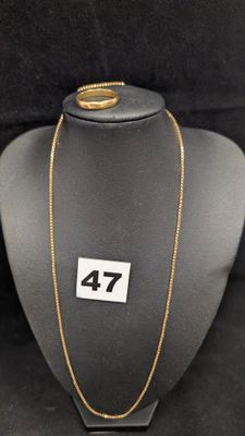 un gros plan d'un collier porté par un mannequin, sur lequel figure le chiffre 47