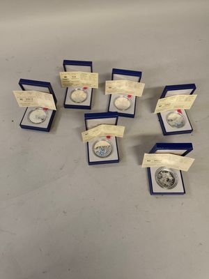 a group of silver coins in a blue box on a table