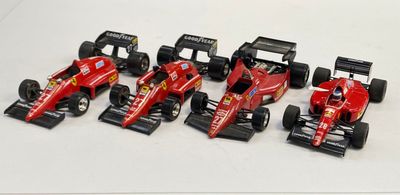 six voitures de course rouges alignées sur une surface blanche