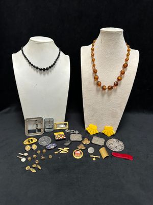 two mannequins with various jewelry on display on a black background