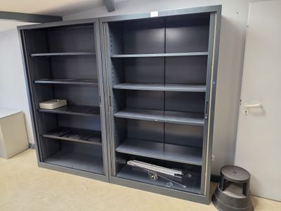 a large metal bookcase in the corner of a room