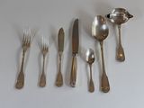 un grand nombre de cuillères et de fourchettes en argent disposées sur une table