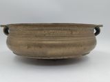 an old bronze bowl with handles on a white background