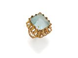 a close up of a gold ring with a blue topaz stone