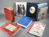 several books are lined up on a table with a gray background