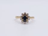 a yellow gold ring with a blue sapphire and white diamonds