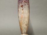 a vase that is sitting on a stand on a gray surface