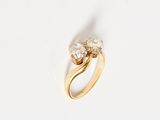 a close up of a gold ring with two diamonds on it