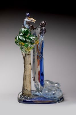 a glass figurine of a man and a woman on a tree