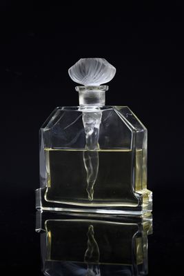 an image of a glass perfume bottle with a flower on it