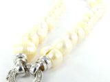 collier composé de perles blanches et d'un fermoir en argent, sur fond blanc