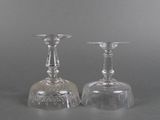 two clear glass candlesticks sitting on top of a table