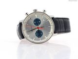 a silver watch with a blue face on a white surface