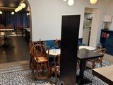 a room with a table, chairs, and a refrigerator in it
