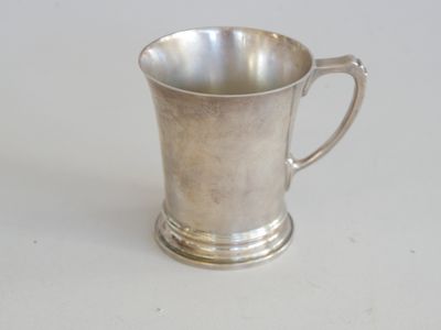 une coupe en argent posée sur une table, sur fond blanc