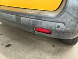 a close up of a yellow car with a red tail light