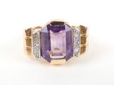 a close up of an amethorate and diamond ring on a white surface