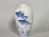 a white vase with a blue fish design on it