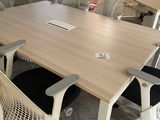 a table with chairs and a laptop on it in a room