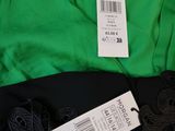 green hoodie with black lace trim and tags on a green shirt