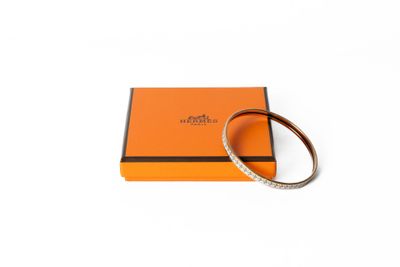 une boîte orange sur laquelle est posé un bracelet