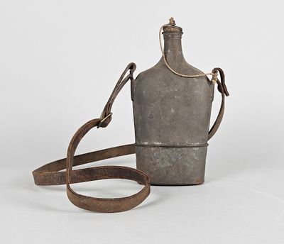 une vieille gourde en métal avec une lanière en cuir, sur fond blanc