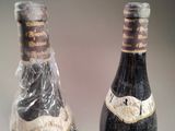 two bottles of wine sitting next to each other on a table