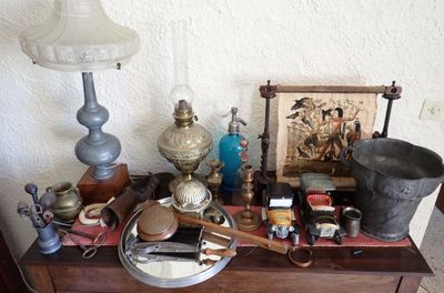 une table sur laquelle se trouvent une lampe, un abat-jour, un tableau et d'autres objets