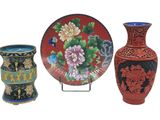 three vases and a plate sitting on a stand