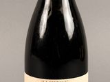 une bouteille de vin posée sur une table à côté d'une bouteille de vin