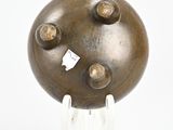 a bronze sculpture of a ball on a stand