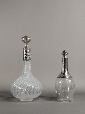 deux vases en verre avec un couvercle en argent et une bouteille en verre surmontée d'un oiseau