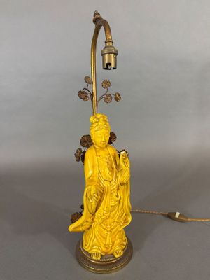 une image représentant une lampe jaune surmontée d'une statue