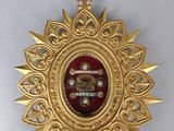 a close up of a gold medal with a cross on it