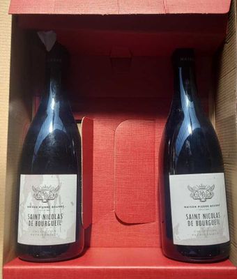 two bottles of wine in a red box on a table