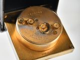 a gold clock sitting on top of a black box