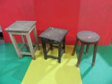 trois tabourets et une table posés sur un sol jaune et rouge