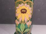 un vase vert orné d'une fleur jaune et rose